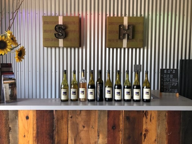 Wine bottles lined up at the bar inside of the Soaring Hawk tasting room.